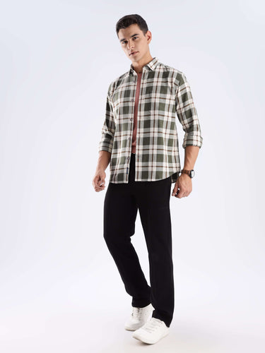Man wearing a Meteor Green recycled cotton checked shirt with stylish black pants, showcasing sustainable fashion.