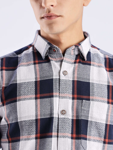 Close-up of a man wearing a stylish blue matrix check shirt made from recycled cotton with a sustainable design.