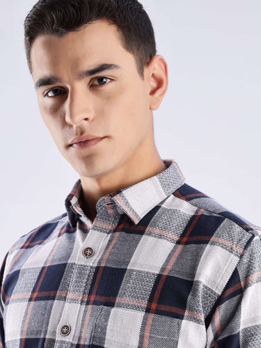 Model wearing a blue and gray checked recycled cotton shirt, highlighting its sustainable and stylish design.
