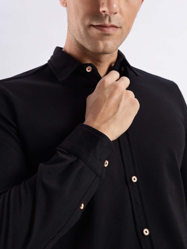Close-up of a man in a Venice Black knitted shirt, featuring 8-way stretch, anti-odour, and premium quality fabric.